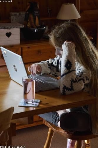WOMAN AT LAPTOP WITH HAND ON HEAD